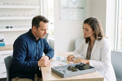 Chef d'une PME discutant du financement des lunettes de travail avec une opticienne professionnelle dans un magasin d'optique